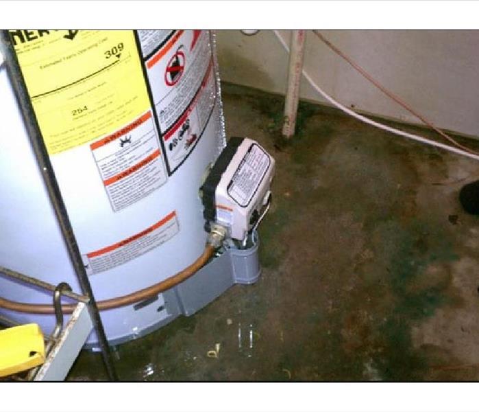Water Heater with water on floor underneath it caused from a leak
