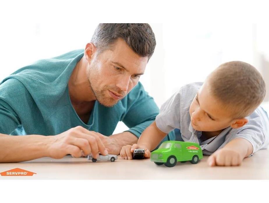 Man and Child playing with car and truck toys