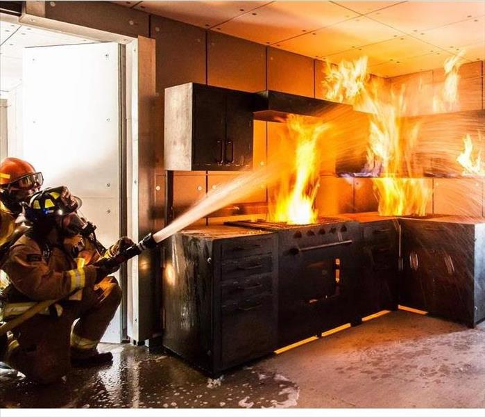 2 firefighters hosing down a fire on the stove and in cabinets - flames 