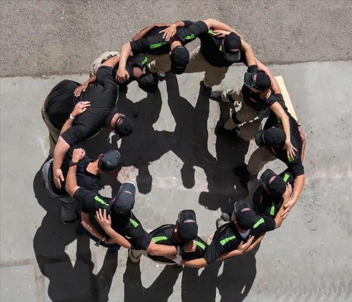Team Employees of SERVPRO in a huddle discussing a plan of action